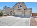 Two story home featuring a two-car garage and manicured landscaping, under a bright blue sky at 30683 W Amelia Ave, Buckeye, AZ 85396