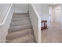 A carpeted staircase with white walls leads to the upper level of the home at 30683 W Amelia Ave, Buckeye, AZ 85396