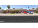 Charming red brick home featuring manicured front yard, tidy landscaping, and a cozy covered porch at 3413 W Ocotillo Rd, Phoenix, AZ 85017
