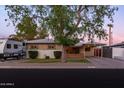 Charming single-story home featuring a covered porch and carport, complemented by mature landscaping and RV parking at 4527 N 12Th Ave, Phoenix, AZ 85013