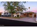 Charming single-story home featuring a covered porch and carport, complemented by mature landscaping and RV parking at 4527 N 12Th Ave, Phoenix, AZ 85013