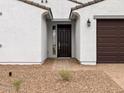 Close up of the home's front door, surrounded by neutral stucco and brick landscaping at 4795 W Hunter Trl, San Tan Valley, AZ 85144