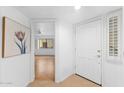 Bright entryway featuring white walls, light tile floors, and a view into a living area with wood floors at 5104 N 32Nd St # 311, Phoenix, AZ 85018