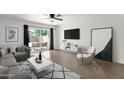 Bright living room with wood floors, large TV, and sliding doors to the patio offers modern comfort at 5316 S Palm Dr, Tempe, AZ 85283