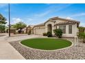 Welcoming home with a desert-style front yard, a two-car garage, and a charming entrance, exuding warmth and character at 628 N El Dorado Dr, Gilbert, AZ 85233