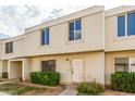 Townhouse featuring light beige siding, a front lawn, a covered porch, and a white door at 6411 S El Camino Dr, Tempe, AZ 85283