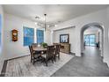 Dining room with wooden table, six chairs, modern chandelier, and access to the living room at 9439 E Trailside Vw, Scottsdale, AZ 85255