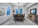 Elegant dining room boasts a modern chandelier, large windows, and a classic wooden table at 9439 E Trailside Vw, Scottsdale, AZ 85255