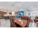 Open concept dining and kitchen area features modern light fixtures and sleek countertops at 10260 W Pinnacle Vista Dr, Peoria, AZ 85383