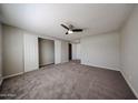 Large bedroom with carpet, ceiling fan, and roomy closet with bi-fold doors at 11275 N 99Th Ave # 170, Peoria, AZ 85345