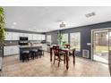 Eat-in kitchen with white cabinets, dark countertops, and seating for four at 11737 W Robin Dr, Sun City, AZ 85373