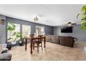 Open concept living room with large windows, wood table set, and comfortable seating area at 11737 W Robin Dr, Sun City, AZ 85373