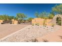 Gated community entrance with stone wall, arched entrance, desert landscaping, and clear blue sky at 13300 E Via Linda -- # 1065, Scottsdale, AZ 85259