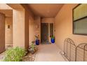 Inviting front entryway featuring neutral toned stucco, decorative potted plants, and a gated doorway at 13300 E Via Linda -- # 1065, Scottsdale, AZ 85259
