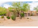 Neutral stucco exterior with stone accents, arched windows, mature trees, and manicured desert landscaping at 13300 E Via Linda -- # 1065, Scottsdale, AZ 85259
