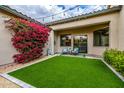 Cozy backyard patio with artificial turf, a blooming bougainvillea and a relaxing seating area at 18502 N 98Th Way, Scottsdale, AZ 85255