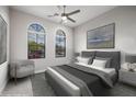 Staged bedroom with a large bed, arched windows, and contemporary decor for a peaceful ambiance at 18502 N 98Th Way, Scottsdale, AZ 85255