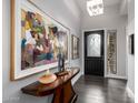 Grand entryway featuring dark wood floors, and a unique console table with eye-catching artwork at 18502 N 98Th Way, Scottsdale, AZ 85255