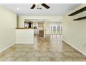 Bright living space showcasing tile floors, neutral paint, ceiling fan, and open access to kitchen and backyard at 23 W Fairmont Dr, Tempe, AZ 85282