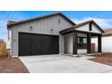 Charming single-story home with a black garage door and desert landscaping at 23403 W Albeniz Pl, Buckeye, AZ 85326