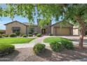 Charming single-story home featuring a well-manicured lawn, lush greenery, and a brick pathway leading to the front door at 2873 E Los Altos Rd, Gilbert, AZ 85297