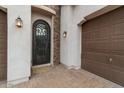 Close up of the home's entrance featuring an ornate wrought iron door and dark-stained garage door at 2926 E Minnezona Ave, Phoenix, AZ 85016