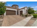 Exterior of a stucco home featuring a three-car garage, tiled roof, and well-manicured landscaping at 2926 E Minnezona Ave, Phoenix, AZ 85016