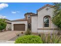Stucco house featuring desert landscaping, a tiled roof, and a two-car garage with driveway at 2926 E Minnezona Ave, Phoenix, AZ 85016