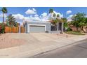 Attractive single-story home with mature palms, a two-car garage, and xeriscaping at 412 W Curry St, Chandler, AZ 85225
