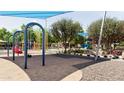 Community playground with swings, slides, and climbing structures under a shaded area for children to enjoy at 5075 S 233Rd Dr, Buckeye, AZ 85326