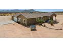 Spacious desert property featuring an expansive lot, a detached garage and a charming single-story home at 54463 W Sunburst St, Maricopa, AZ 85139