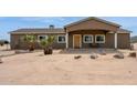 Charming single-story home featuring desert landscaping, a covered porch, and warm exterior lighting at 54463 W Sunburst St, Maricopa, AZ 85139
