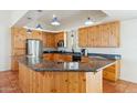 Well-lit kitchen with knotty pine cabinets, a dark granite countertop and stainless steel appliances at 54463 W Sunburst St, Maricopa, AZ 85139