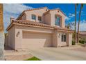 Beige two-story home featuring an attached two-car garage, tile roof and desert landscaping at 7170 W Crystal Rd, Glendale, AZ 85308