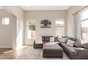 Bright living room with recessed lighting, wood floors, a large sectional sofa, and floating shelves at 7170 W Crystal Rd, Glendale, AZ 85308