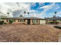 Charming single-story home features a two-car garage, desert landscaping, and blue sky at 7605 N 45Th Dr, Glendale, AZ 85301