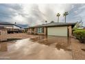 Single-story brick home features a two-car garage, long driveway, and desert landscaping at 7605 N 45Th Dr, Glendale, AZ 85301