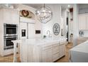 Bright kitchen with white cabinetry, marble countertops, large island, and stainless steel appliances at 7788 E Morning Vista Ln, Scottsdale, AZ 85266