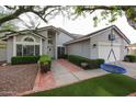 Charming single-story home with mature landscaping and a well-manicured artificial lawn at 9015 E Altadena Ave, Scottsdale, AZ 85260