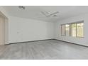 Minimalist bedroom featuring light gray tile flooring, a ceiling fan, and a large window at 1564 W Redwood Ln, Phoenix, AZ 85045
