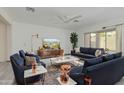 Bright living room boasts modern furnishings, a stylish ceiling fan, and large windows for ample natural light at 1564 W Redwood Ln, Phoenix, AZ 85045