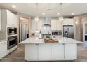 Bright kitchen boasting an island with granite countertops, stainless steel appliances, and white cabinetry at 26242 N 122Nd Ln, Peoria, AZ 85383