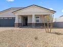 Charming single-story home with a covered entry, stone accents, and a well-maintained desert landscape at 4020 S 176Th Dr, Goodyear, AZ 85338