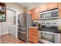 Well-lit kitchen featuring stainless steel appliances, wooden cabinets, and granite countertops at 5345 E Van Buren St # 258, Phoenix, AZ 85008