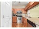 Well-lit kitchen featuring stainless steel appliances, granite countertops, and wooden cabinets at 5345 E Van Buren St # 258, Phoenix, AZ 85008