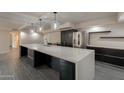 Spacious kitchen features a large island, stainless appliances, and modern lighting and gray tile flooring at 7960 E Camelback Rd # 110, Scottsdale, AZ 85251