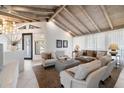 A modern living room showcases a high ceiling, exposed wood beams, ample natural light, and comfortable seating at 11416 N Blackheath Rd, Scottsdale, AZ 85254