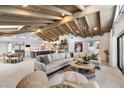 Spacious living room features an open-concept design with a beamed ceiling, large sofa, and adjacent kitchen at 11416 N Blackheath Rd, Scottsdale, AZ 85254
