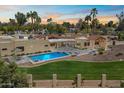 An aerial view of a luxury home featuring a sparkling pool, spa, green lawn and desert landscaping at 11416 N Blackheath Rd, Scottsdale, AZ 85254