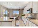 Well-equipped kitchen with a large island, stylish pendant lighting, and views of the backyard at 11609 W Andrew Ln, Peoria, AZ 85383